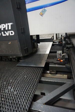 Sheared steel being punched on a turret punch machine before being formed into stair components | SCS | Stair Components & Systems | a Division of Eberl Iron Works, Inc. | Buffalo, NY, USA